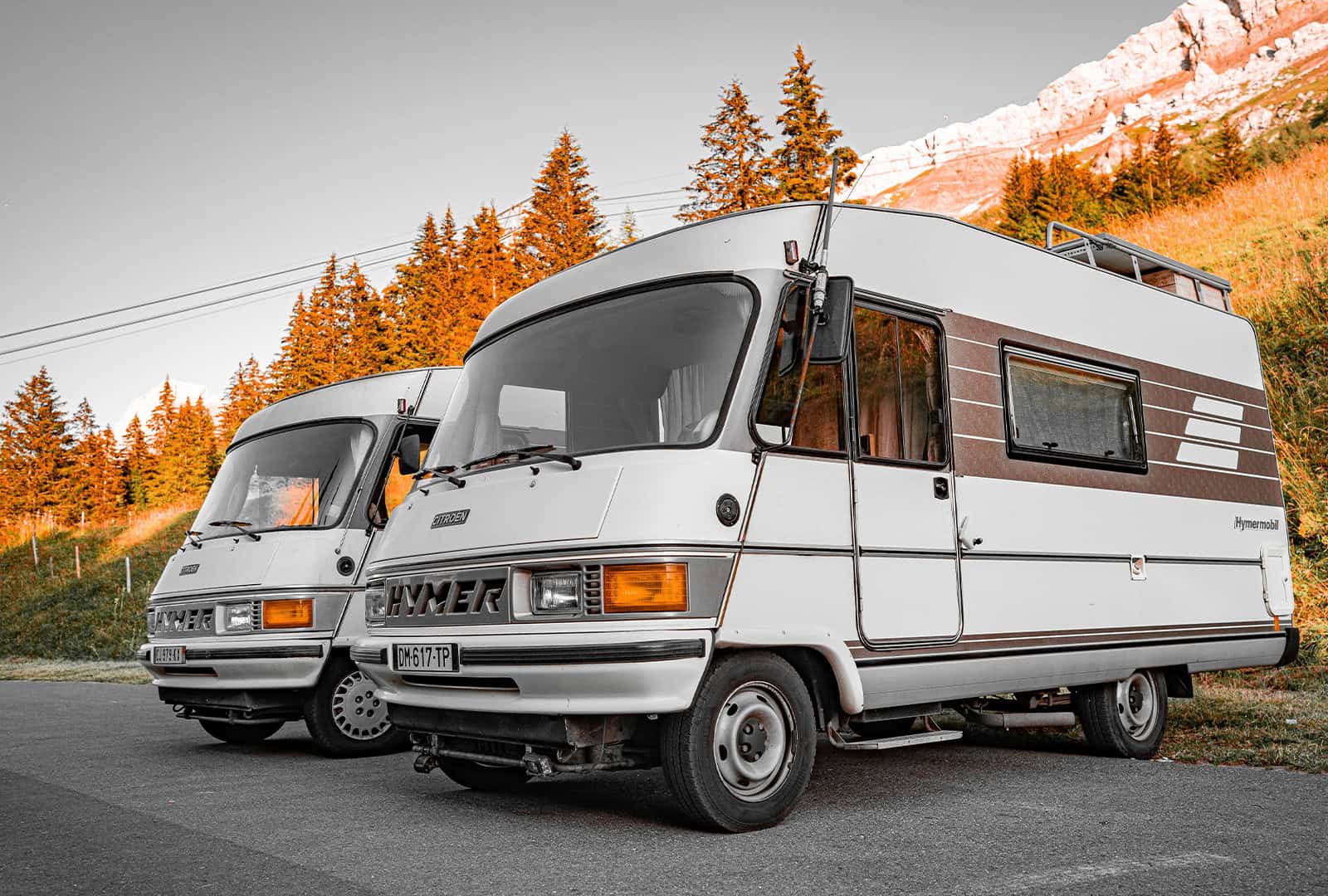 Cheapest Motorhome insurance a twin pair of hymer motorhomes infronts of trees